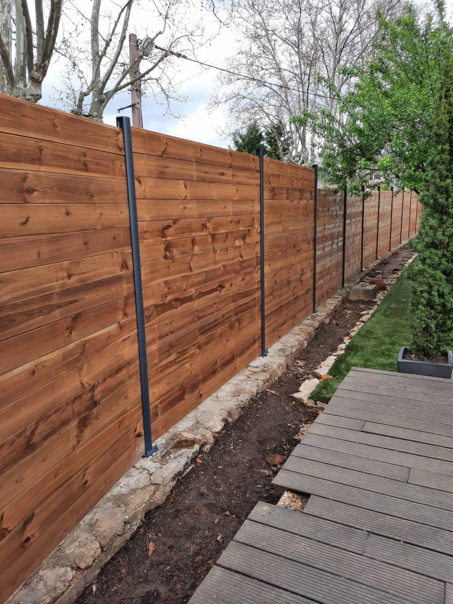 Un jardin mis en valeur par la palisse en bois à Bras.