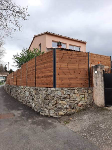Une belle entrée de maison avec une palissade en bois