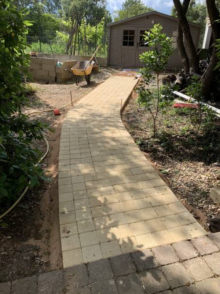 Une allée en pavés carrés couleur sable